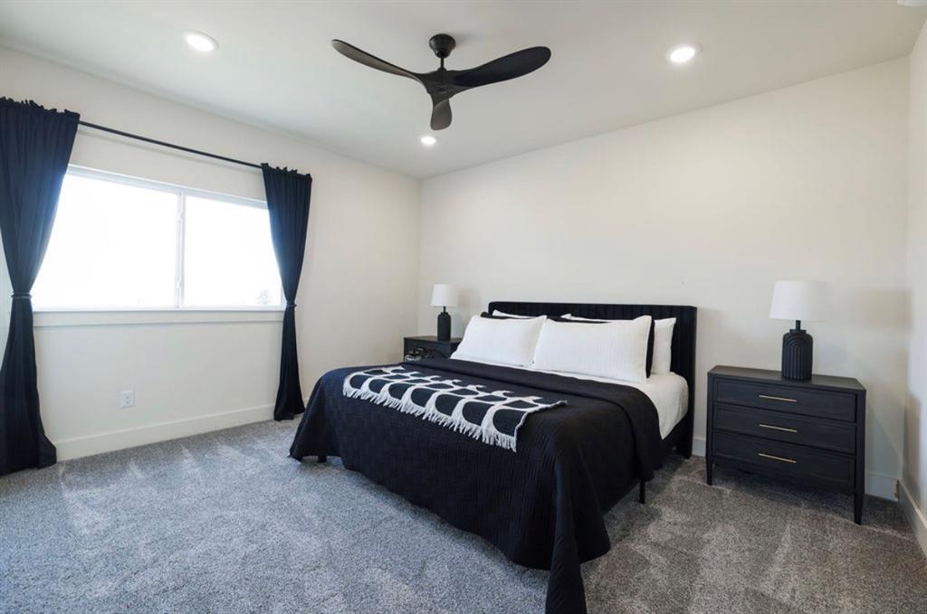 6724 Clearwater Ranch Road Wills Point, TX 75169 - Photo 29 of 38 a spacious bedroom with a bed and a ceiling fan