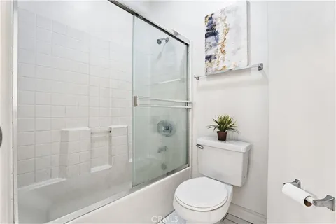 a white toilet sitting next to a bath tub