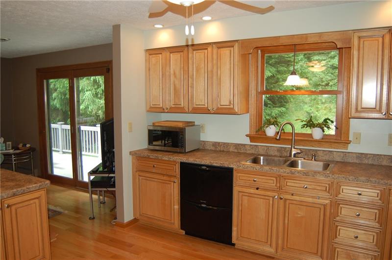 183 Dehaven Road Beaver Falls, PA 15010 - Photo 6 of 23 Kitchen connects to seating area and walk-out to wrap around deck. Eat-in counter to left.