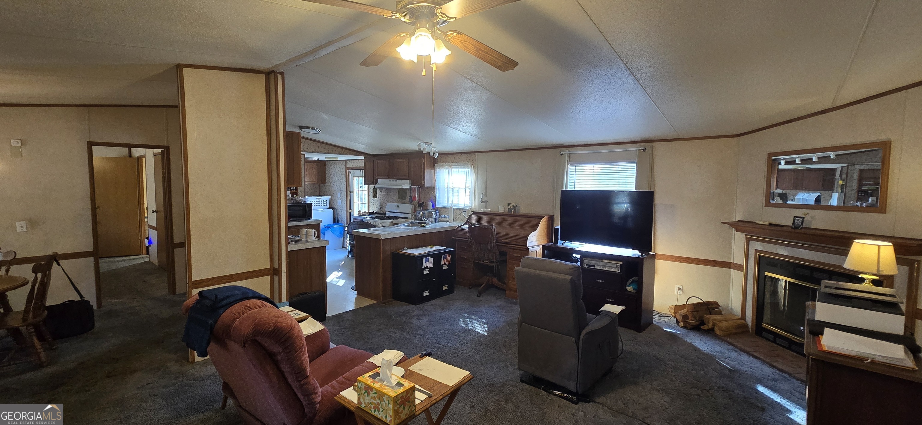 912 Druid Street Dublin, GA 31021 - Photo 16 of 32 a living room with furniture a flat screen tv and a refrigerator