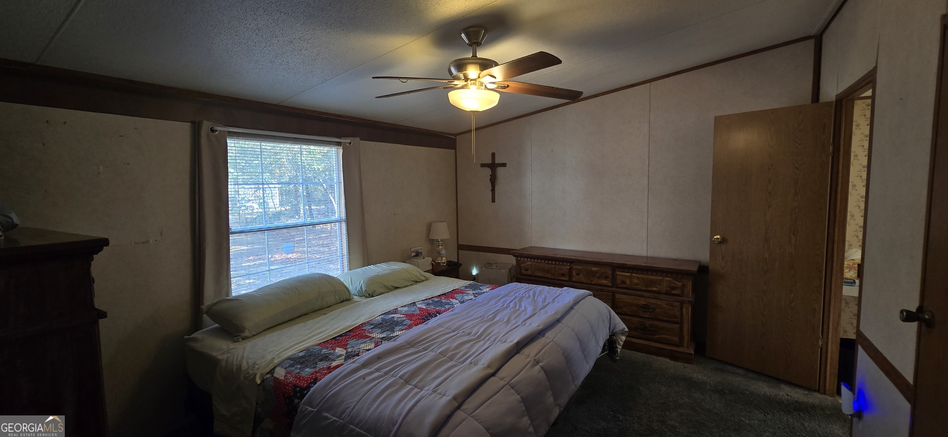 912 Druid Street Dublin, GA 31021 - Photo 21 of 32 a bedroom with a bed and a chandelier