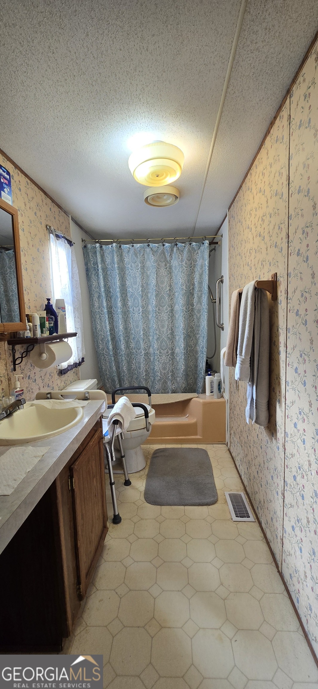 912 Druid Street Dublin, GA 31021 - Photo 23 of 32 a bathroom with a tub sink and mirror