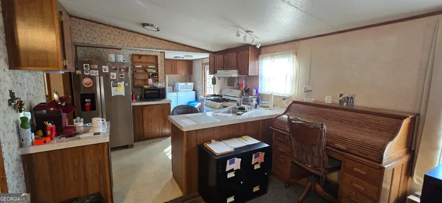 a kitchen with a refrigerator and a stove top oven