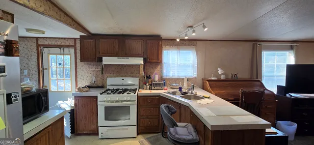 a kitchen with a sink stove and microwave