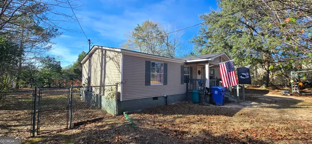 a front view of a house with a tree