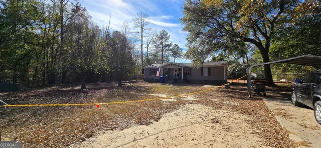 a view of a house with backyard and a trees