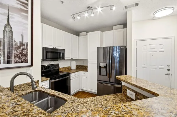 a kitchen with a sink stove top oven and refrigerator