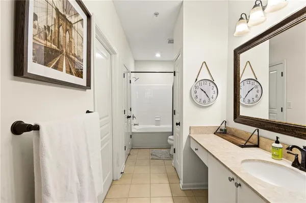 a bathroom with a granite countertop sink mirror and a bathtub