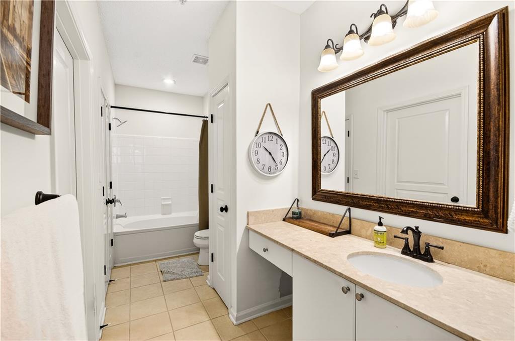 10 Perimeter Summit Boulevard, Unit 4113 Brookhaven, GA 30319 - Photo 22 of 53 a bathroom with a granite countertop sink mirror and a bathtub