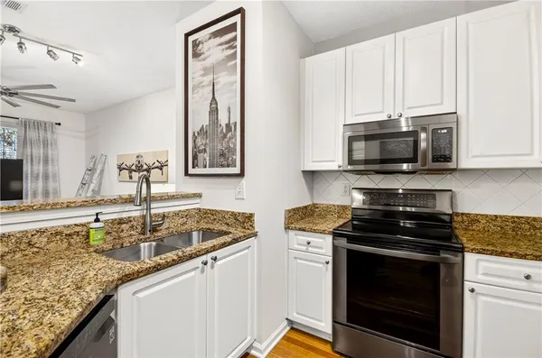 a kitchen with stainless steel appliances granite countertop a sink stove and microwave