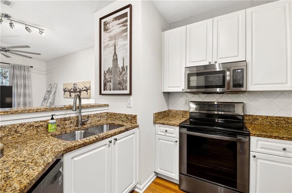 10 Perimeter Summit Boulevard, Unit 4113 Brookhaven, GA 30319 - Photo 8 of 53 a kitchen with stainless steel appliances granite countertop a sink stove and microwave