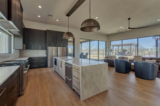 a large kitchen with stainless steel appliances and a large window