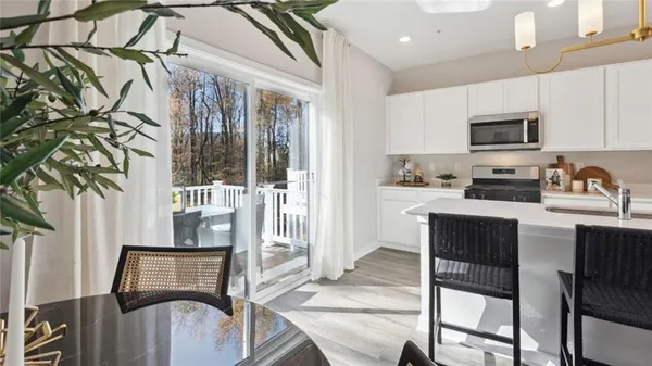 a kitchen with stainless steel appliances granite countertop a stove top oven a sink a refrigerator and white cabinets