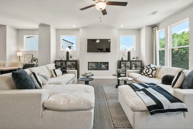a living room with furniture a fireplace and a flat screen tv