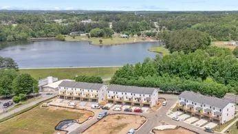 an aerial view of a house with a garden and lake view