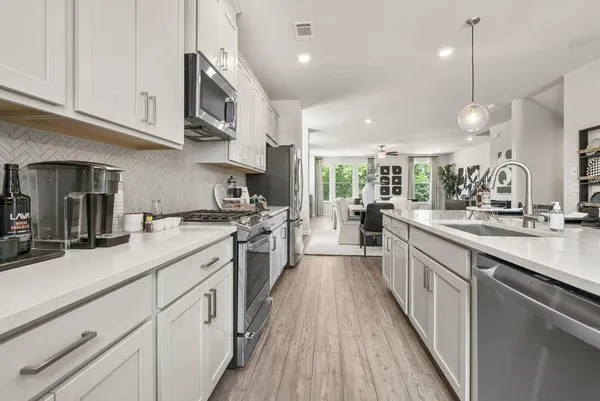 a large kitchen with stainless steel appliances lots of counter space and a sink