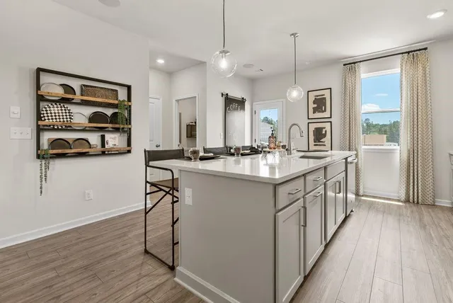 a kitchen with a sink stove and wooden floor