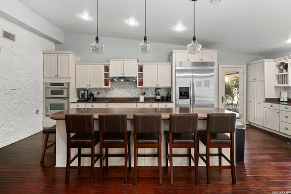 a large kitchen with stainless steel appliances granite countertop a lot of counter space and wooden floor
