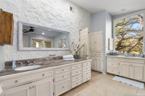 a bathroom with a sink a mirror and a glass door shower