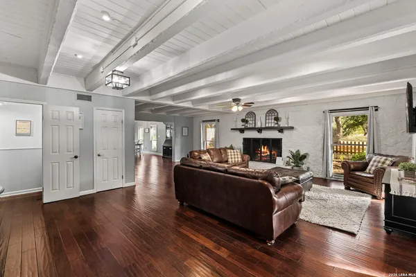 a living room with furniture a fireplace and wooden floor