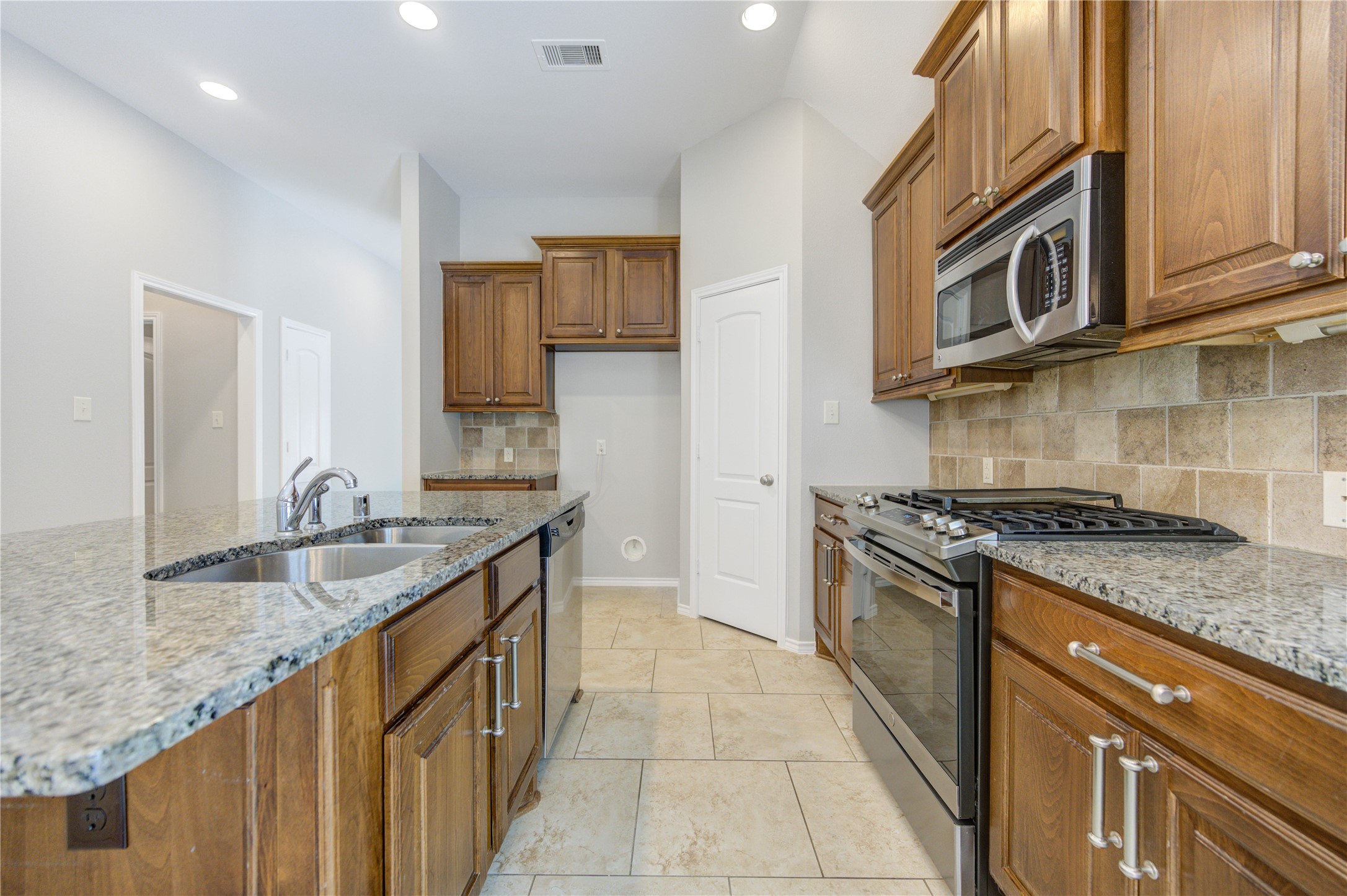 27407 Gatlin Lane Spring, TX 77386 - Photo 15 of 35 The heart of the home features a spacious island kitchen that flows effortlessly into the dining and living areas, creating the perfect space for gathering and entertaining. Rich cabinetry, granite countertops, and soaring ceilings make this open-concept design both beautiful and functional.