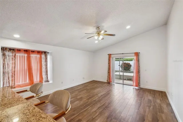 an empty room with windows and ceiling fan