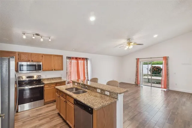 a kitchen with stainless steel appliances granite countertop a sink stove and refrigerator
