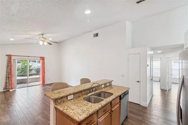 a kitchen with granite countertop a sink and a refrigerator