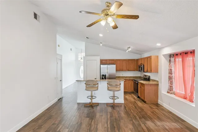 a living room with stainless steel appliances kitchen island granite countertop furniture a rug and a kitchen view