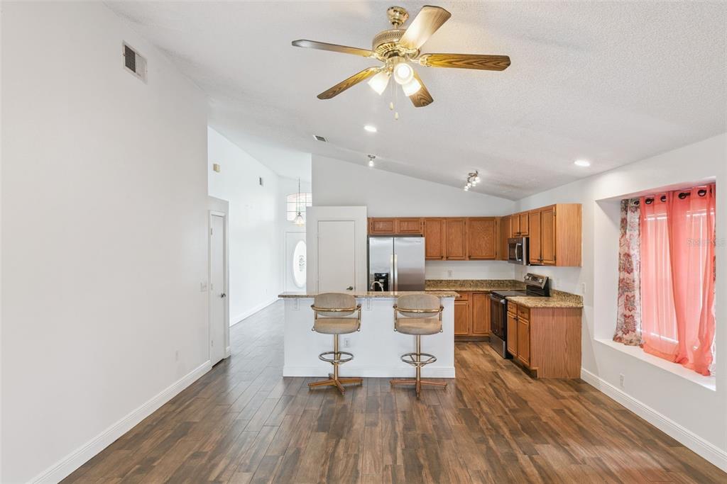 2732 Cahill Way Lake Mary, FL 32746 - Photo 7 of 20 a living room with stainless steel appliances kitchen island granite countertop furniture a rug and a kitchen view