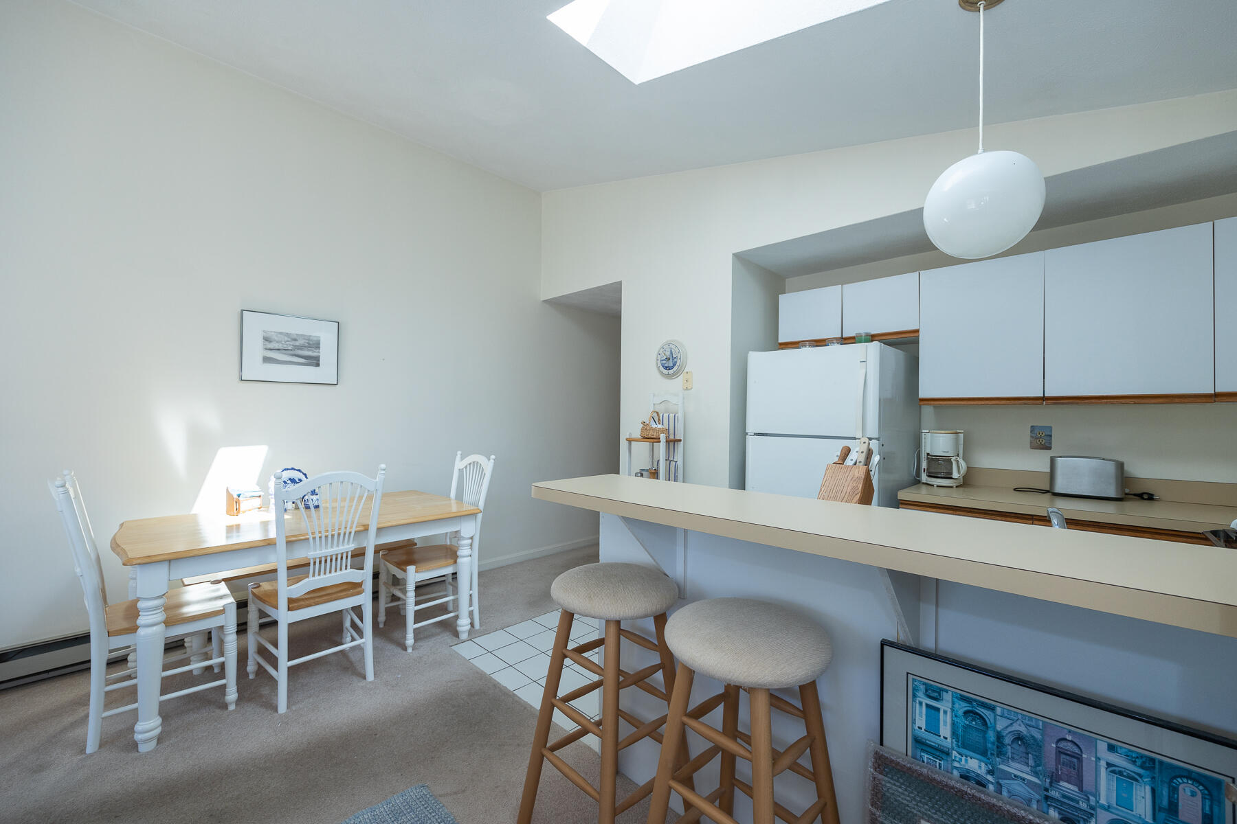 35 Ashumet Road, Unit 7D Mashpee, MA 02649 - Photo 7 of 31 a kitchen with a dining table chairs and white cabinets
