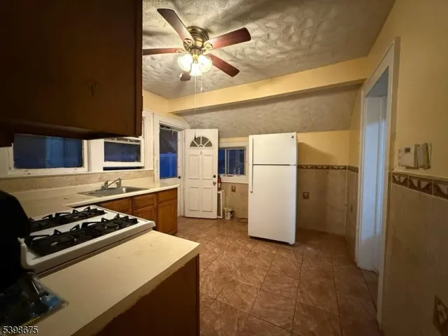 a kitchen with a refrigerator and a stove top oven