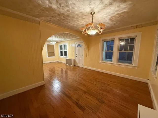 a view of a room with wooden floor and chandelier