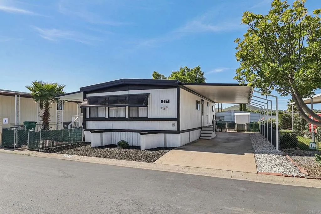 10767 Jamacha Spring Valley, Unit 217 Spring Valley, CA 91978 - Photo 3 of 24 a front view of a house with a yard and garage