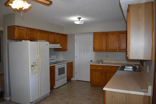 a kitchen with stainless steel appliances sink a refrigerator and a stove