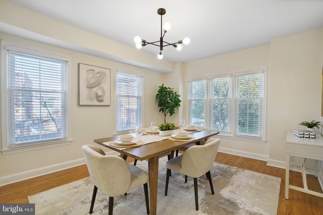 a dining room with furniture a chandelier and wooden floor