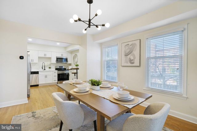 a view of a dining room with furniture a kitchen and chandelier