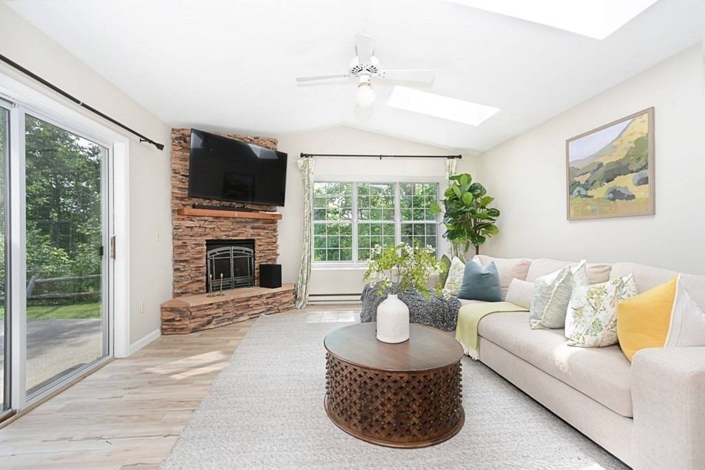 307 Ridgefield Circle, Unit C Clinton, MA 01510 - Photo 9 of 18 a living room with furniture a fireplace and a flat screen tv