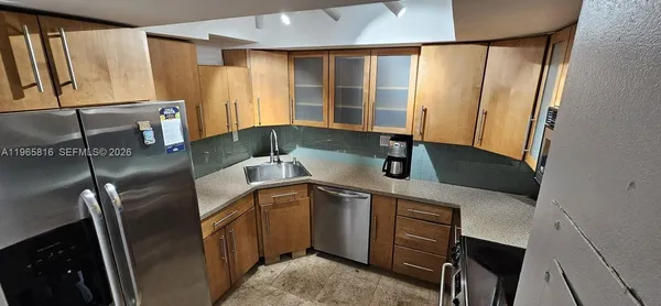a kitchen with stainless steel appliances granite countertop a sink refrigerator and microwave