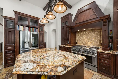 a kitchen with stainless steel appliances granite countertop a stove and cabinets