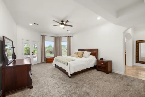 a spacious bedroom with a bed and glass wall