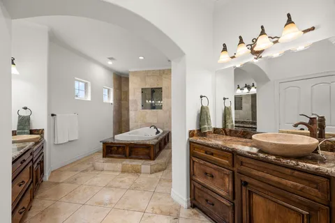 a spacious bathroom with a granite countertop sink a large mirror and a