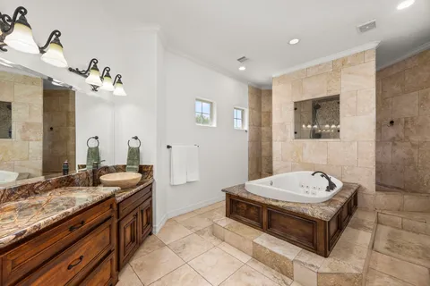 a spacious bathroom with a tub sink and mirror