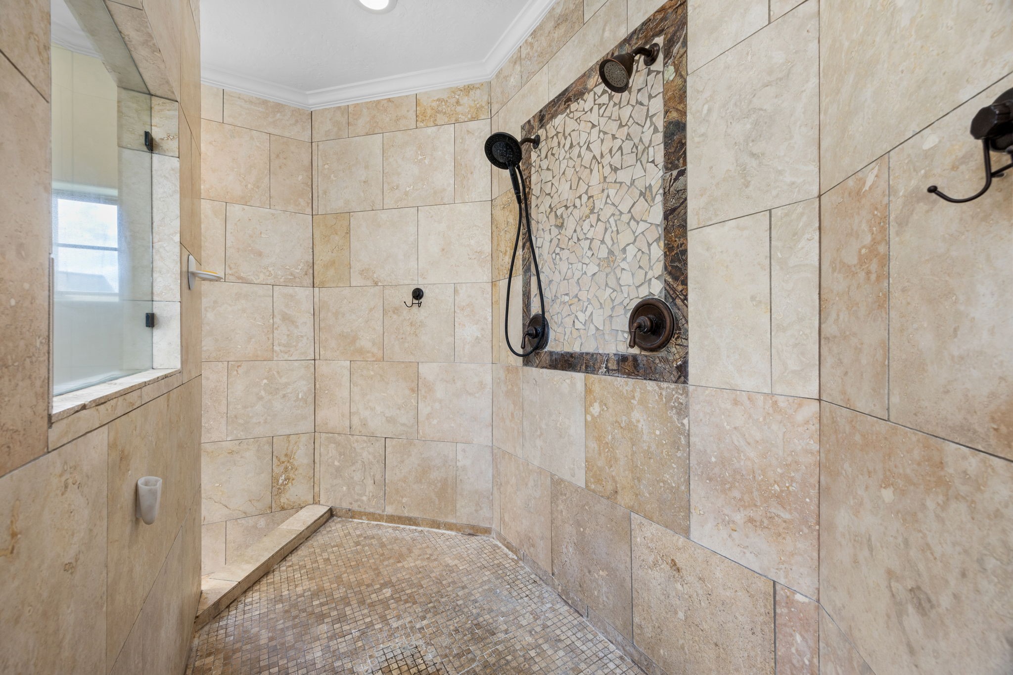 4611 Oasis Point Katy, TX 77493 - Photo 18 of 41 It doesn't get more spa-like than this! Multiple shower heads, tile base, and inlaid stone details in the primary shower, which overlooks the jetted tub below.