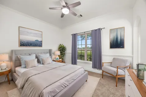 a bedroom with a large bed and a chandelier