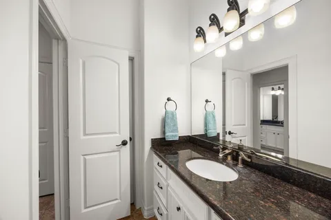 a bathroom with a granite countertop sinks a mirror and a shower