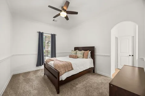 a spacious bedroom with a bed and a chandelier