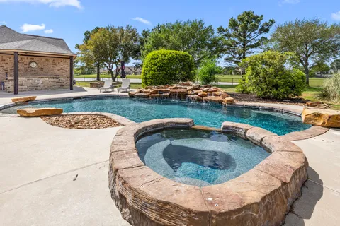 a view of a swimming pool with a yard and plants