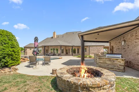a view of a house with backyard and sitting area