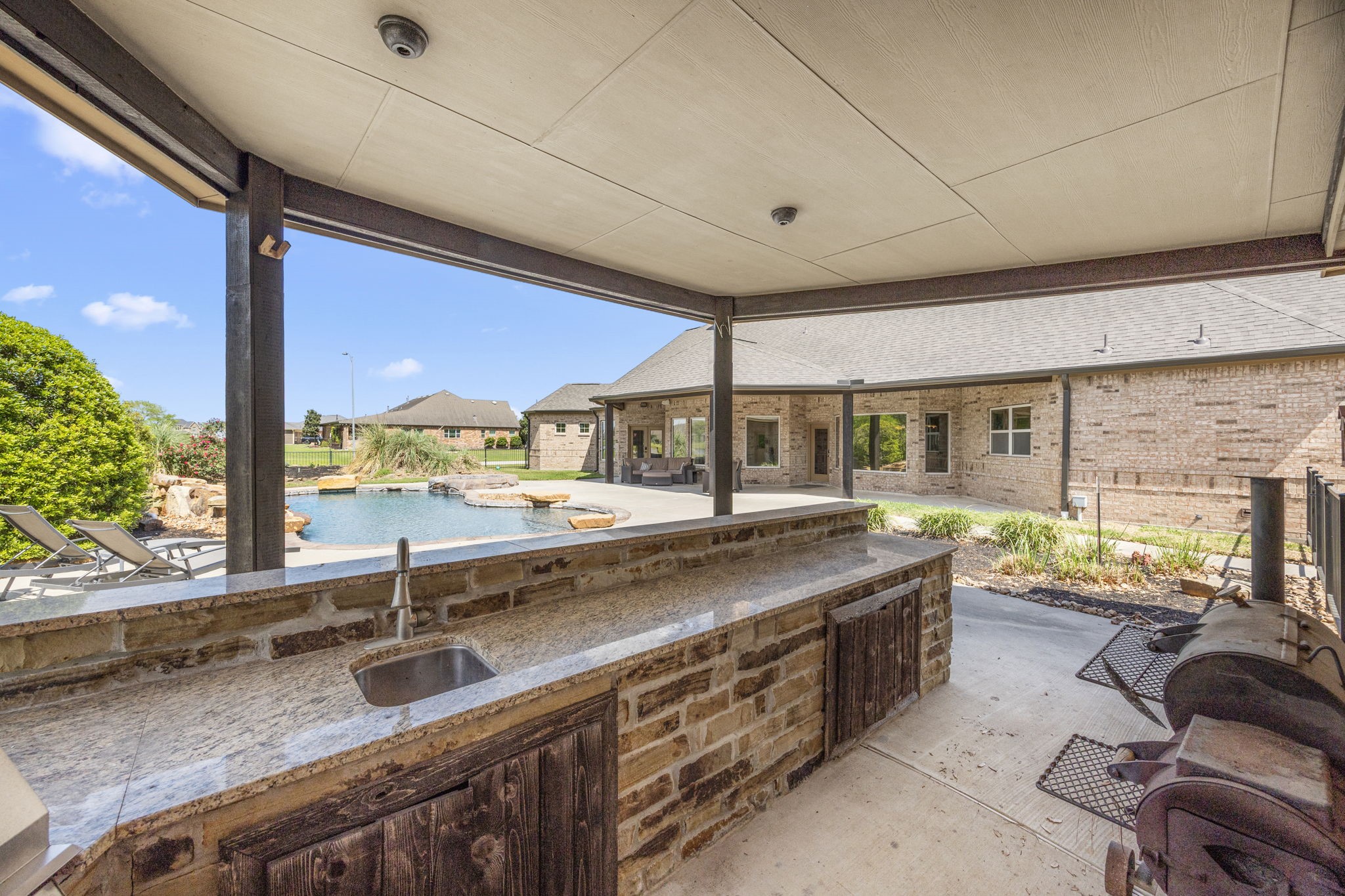 4611 Oasis Point Katy, TX 77493 - Photo 36 of 41 Serve guests from the shaded outdoor kitchen. Granite countertops and brick/stone accents coordinate beautifully with the exteri0or of the home.